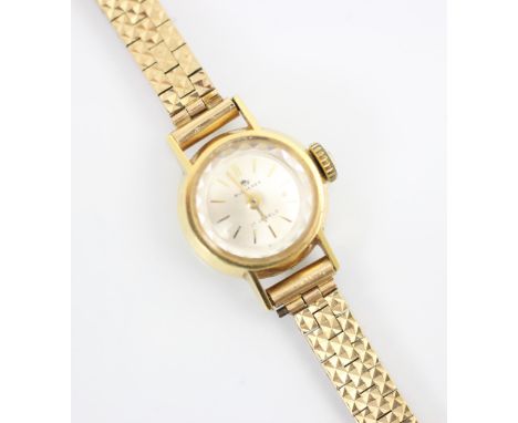 A yellow metal Bucherer ladies wrist watch, the circular white dial with baton markers, set to plain polished case stamped '1