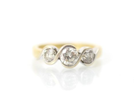 A late 20th century bespoke diamond three stone ring, the three graduated round cut diamonds within openwork white metal swir