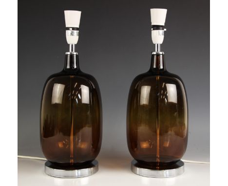 A pair of contemporary amber glass table lamps, of ovoid form, upon an integral chromed plinth base, 42cm high (2) Lighting l