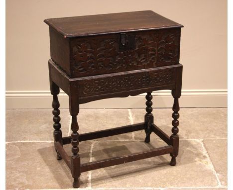 A 17th century carved oak bible box on stand, the rectangular moulded hinged cover opening to a vacant interior, over a blind