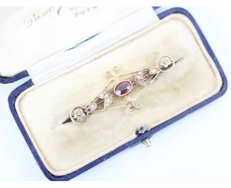 An Edwardian style garnet bar brooch, the oval cut garnet within openwork mount with split pearl leaf designed detail, stampe