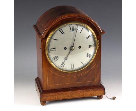 An Edwardian mahogany bracket clock, with arched case and 21cm silvered dial applied with Roman numerals, enclosing the two t