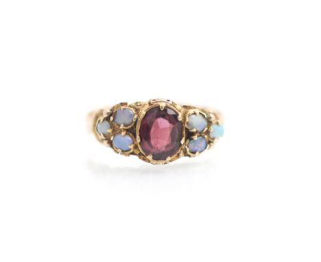 A 19th century garnet and opal ring, the central oval cut garnet within claw setting edge with three small opal cabochons to 