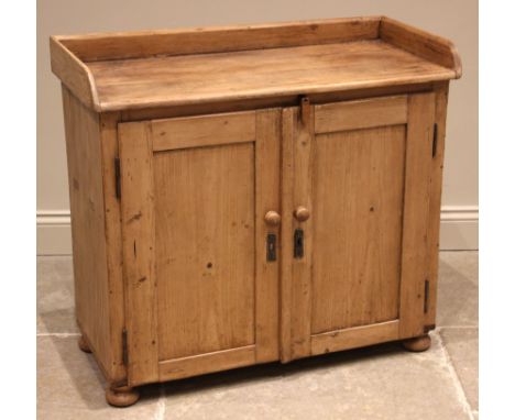 A Victorian pine tray top cupboard, the rectangular top with a three quarter gallery, over a pair of cupboard doors opening t