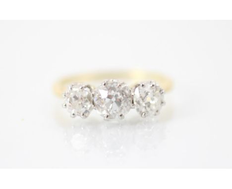 A 20th century diamond three stone ring, the central old cut diamond with smaller old cut diamond to each side, all set in wh