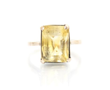 A citrine dress ring, the emerald cut citrine within yellow metal four claw setting, leading to plain polished shank, ring si