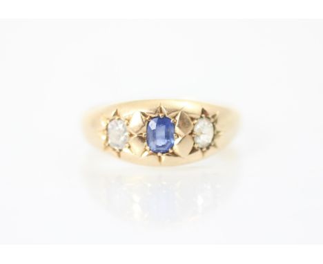 A 19th century untested sapphire and diamond three stone ring, the central cushion cut blue stone with old cut diamond to eac