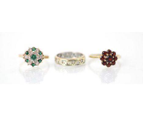 A selection of three dress rings, including a 9ct red stone set cluster ring, the nine round cut stones within flowerhead des