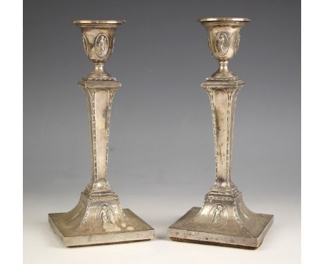 A pair of Edwardian silver candlesticks, Hawksworth, Eyre and Co Ltd, Sheffield 1900, the urn shaped sconces with oval cartou