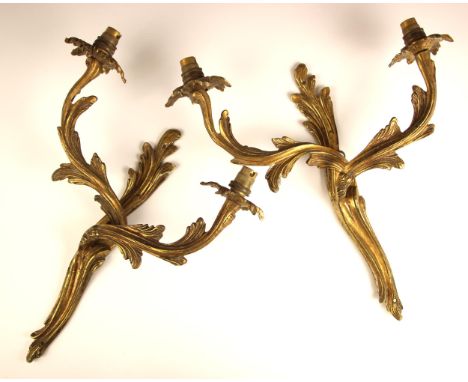 A pair of twin branch gilt brass Rococo style wall sconces, 20th century, modelled as intwined acanthus leaves, each ogee arm