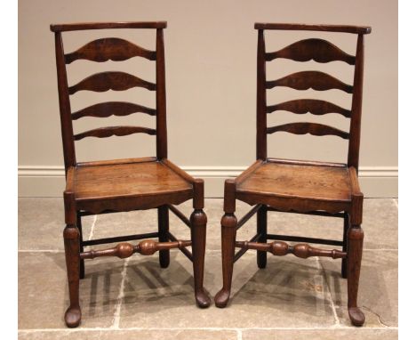 A pair of 19th century provincial ash ladder back chairs, each with a board seat, shaped apron upon turned fore legs extendin