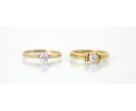 A yellow metal bespoke diamond solitaire ring, the round cut diamond with grooved shoulders leading to plain shank, stamped '