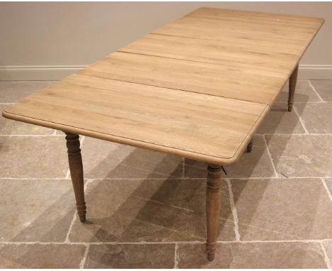 An Oka 'Charlotte' extending dining table, constructed from alder wood with a weathered oak finish, the moulded drop leaf top