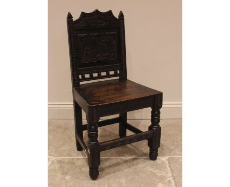 A 17th century style panel back oak hall chair, 19th century, the back panel carved with a hunting scene over a board seat an