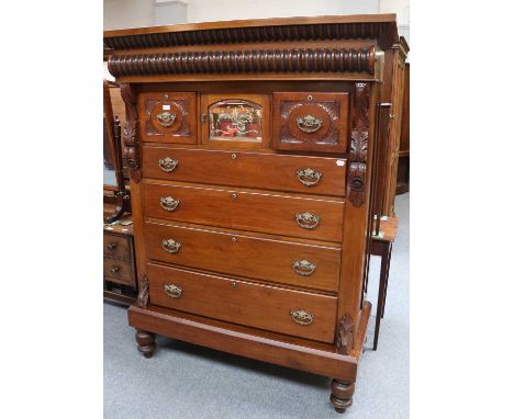 A Victorian Walnut Scotch Chest, heavily carved cornice, central mirrored cupboard flanked by two small drawers, four graduat