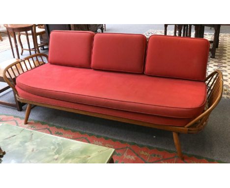 An Ercol Elm Sofa, red upholstered cushions, solid back, stick ends, tapered turned legs, 210cm wideThe back requires tightni