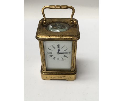 A small gilt case carriage clock the enamel dial with Roman numerals, fitted in original case 7 cm .