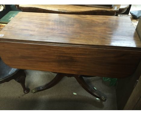 A Regency mahogany breakfast table the twin flap top on a shaped pillar with splayed legs terminating with brass cap and cast