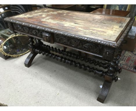 A heavily carved Victorian oak library table with barley twist supports, approx 128cm x 67cm x 75cm.