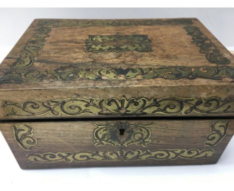 A Recency work box with brass inlay enclosing a fitted interior with various sewing tools .