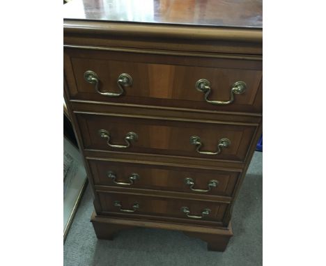 A small reproduction chest of drawers fitted with four drawers on bracket feet .70 cm heigh 45 by 35 cm .