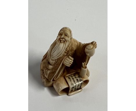 A carved Ivory netsuke in the form of an elder, signed to underside.