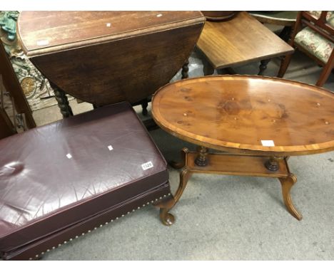 A red leather upholstered foot stool an oval Yew wood occasional table an oak gateleg table (3)