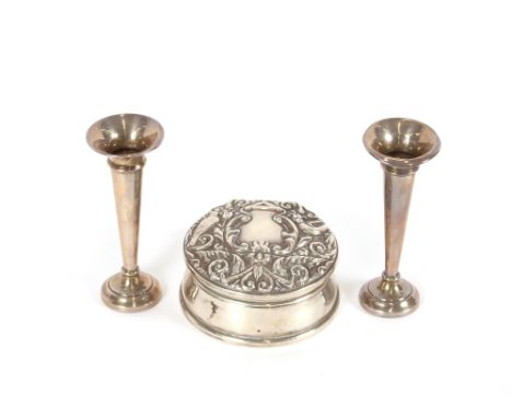 A pair of small silver trumpet shaped spill vases, 10.5cm high; and a circular silver trinket box, with foliate embossed deco