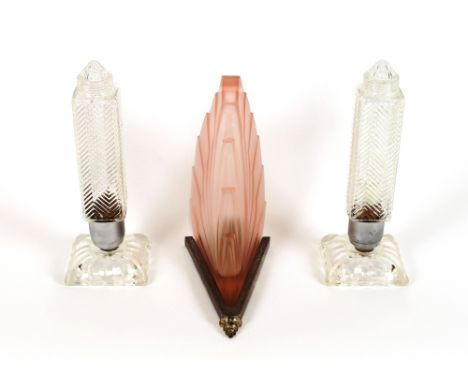 A pair of American moulded glass sky scraper table lamps; and an Art Deco wall lamp having pink moulded glass shade