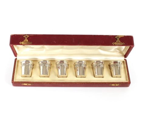 A cased set of six continental white metal liqueur cups, with raised foliate decoration