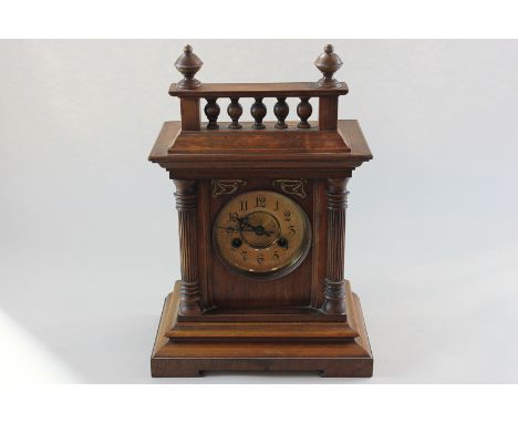 A wooden cased mantel clock with circular dial and Arabic numerals, and eight-day movement striking on a gong, 41cm high