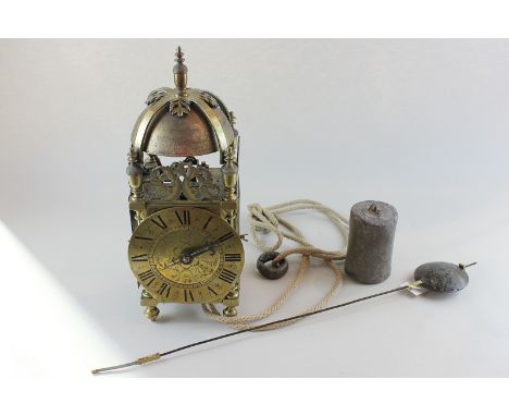 An 18th century brass lantern clock with circular engraved dial and Roman numerals, the bell above movement with opening side