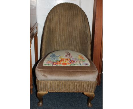 A Lloyd Loom style chair with floral tapestry seat