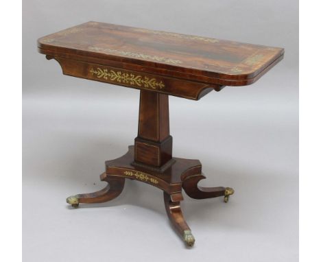 REGENCY ROSEWOOD FOLD OVER CARD TABLE, the rounded rectangular top with brass foliate inlay, baize lined surface above a slig