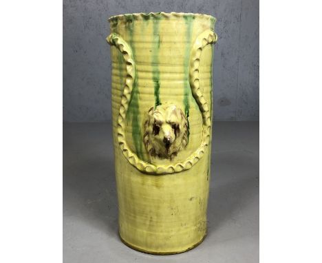 Ceramic glazed stick / umbrella stand, signed to base with raised dog head design, approx 48cm tall (A/F)