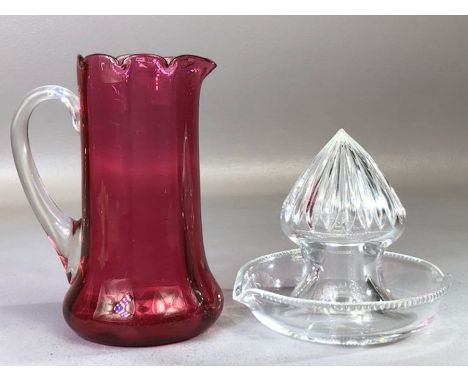William Yeoward glass lemon squeezer and a cranberry glass jug with fluted rim, approx 14cm in height