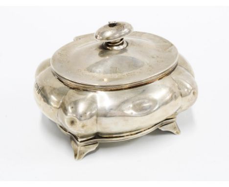 George V silver tea caddy of lobed form, the hinged cover opening to reveal the original silver caddy spoon to the under side