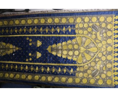 Late 19th century or early 20th century Indian hanging panel, the blue silk ground heavily embroidered in gold thread, the ce