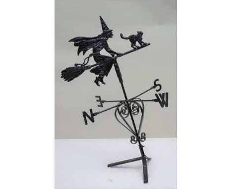 A WITCH ON HER BROOMSTICK WEATHER VANE, with a black cat, cast metal direction indicator on a wrought iron compass position b