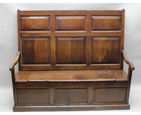 A LATE 18TH CENTURY OAK BENCH SETTLE (with later alterations), having panelled back and open arms over a box base with three-