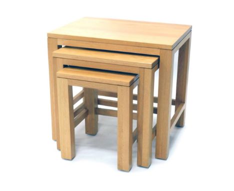 A nest of three light oak tables, of rectangular form, on block stiles, the largest 52cm high, 55cm wide, 41cm deep. 