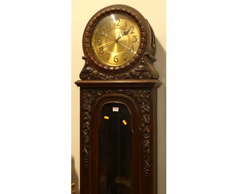 An early 20th century oak longcase clock, having a drum head top with brass Arabic dial, three-train weight driven striking a