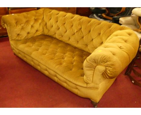 A circa 1900 and later mustard fabric button upholstered two-seater Chesterfield, raised on ring turned squat forelegs to cas