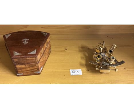 A brass sextant in teak box