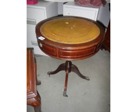 A mahogany drum table on tripod base.