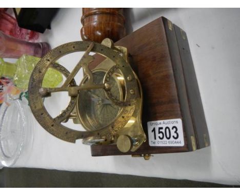 A brass compass in wooden case.
