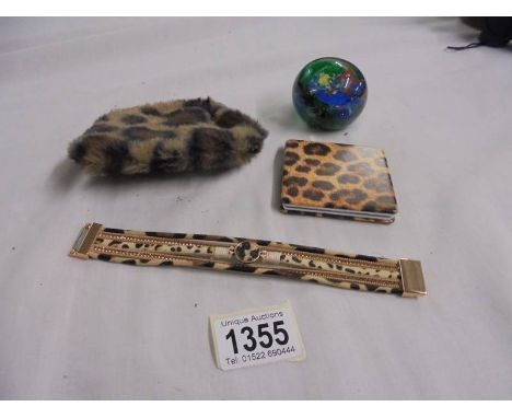 A handbag mirror, purse, bracelet and paperweight.