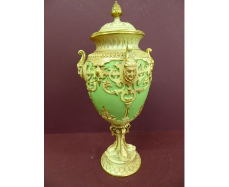 Late 19thC Royal Worcester porcelain urn with cover , flaming finial decoration of pixie masks, griffins, column having four 