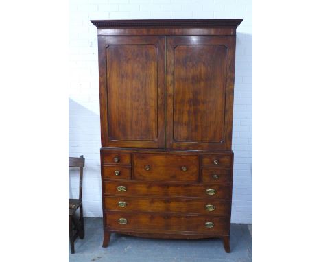 Georgian mahogany linen press, the projecting dentil cornice over a pair of panelled doors, above a secretaire drawer with fi