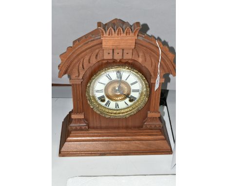 A LATE 19TH CENTURY WALNUT CASED AMERICAN ANSONIA MANTEL CLOCK, the carved pediment above enamel dial with Roman numerals, ei